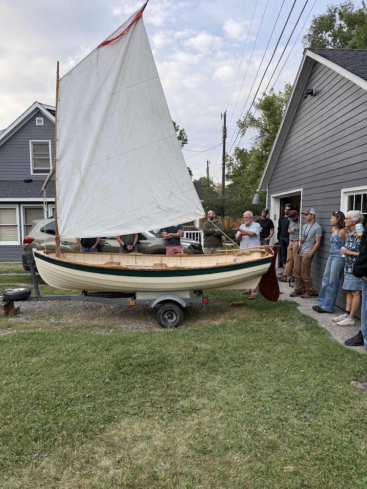 A handmade wooden sailboat shown at a guild meeting